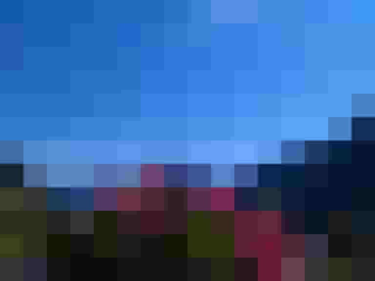 Blick auf die Berge und blühende Geranien in Rauris an einem sonnigen Tag.